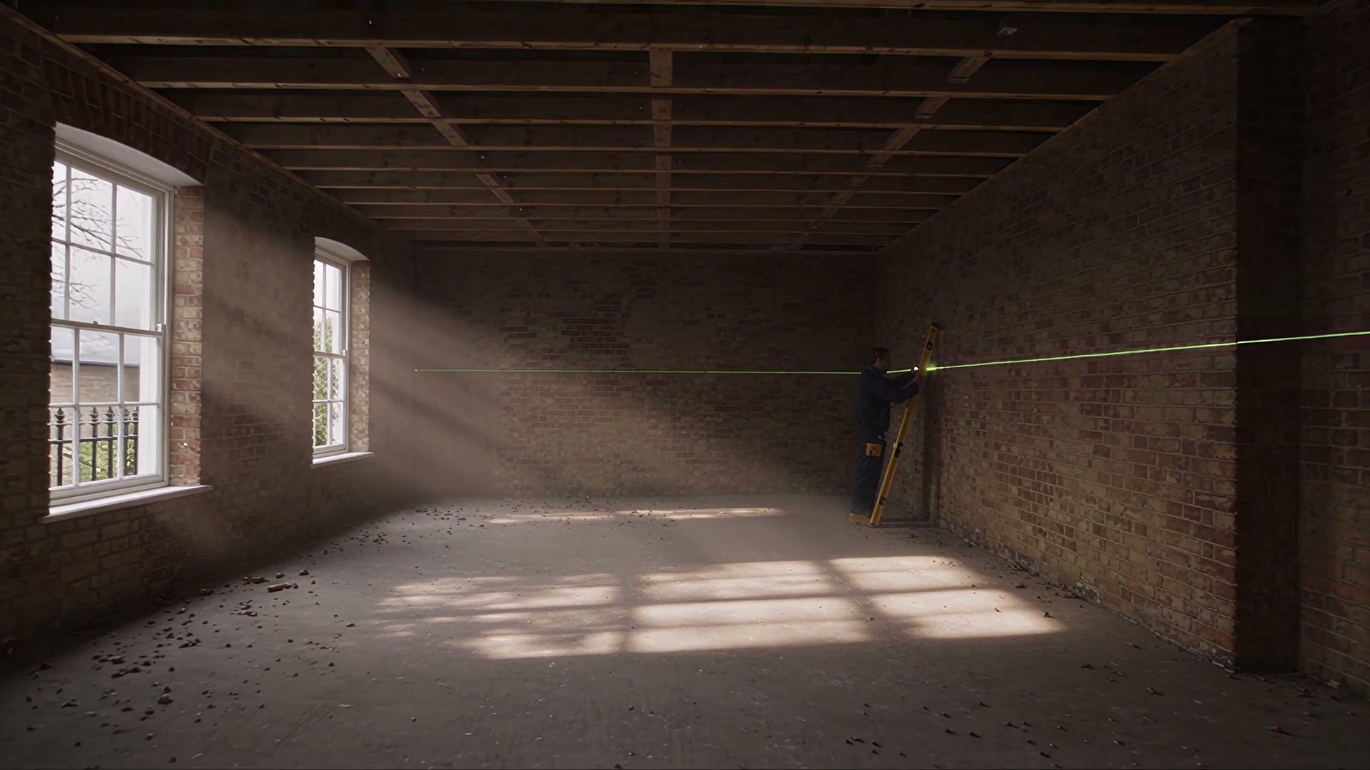 A stripped room with bare brick walls, exposed joists and sunlight on the floor